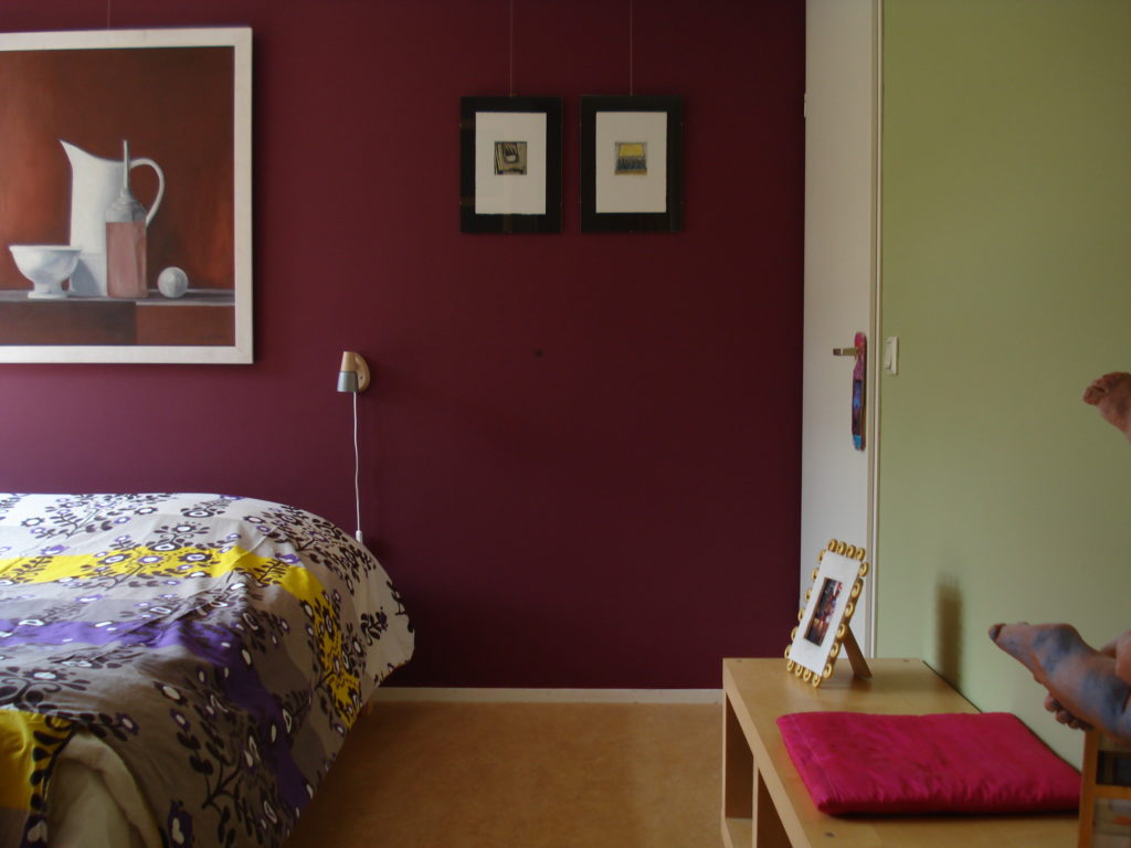 Wijnrood en olijfgroen achter en naast het bed: kleur ideeën voor in de slaapkamer