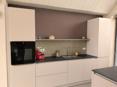 Cremekleurige keuken met paarsgrijze achterwand en groene tegels